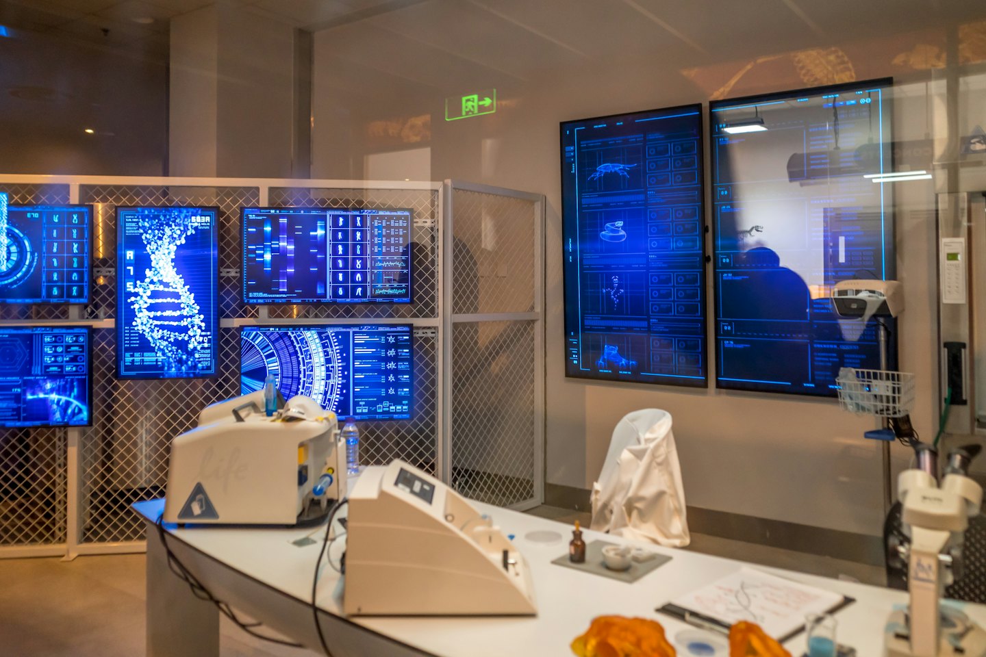 Digital screens display DNA helix and genetic data in a modern lab.